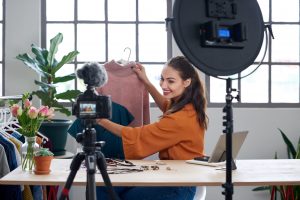 Young female vlogger recording content for her online fashion channel on social media, giving fashion advice